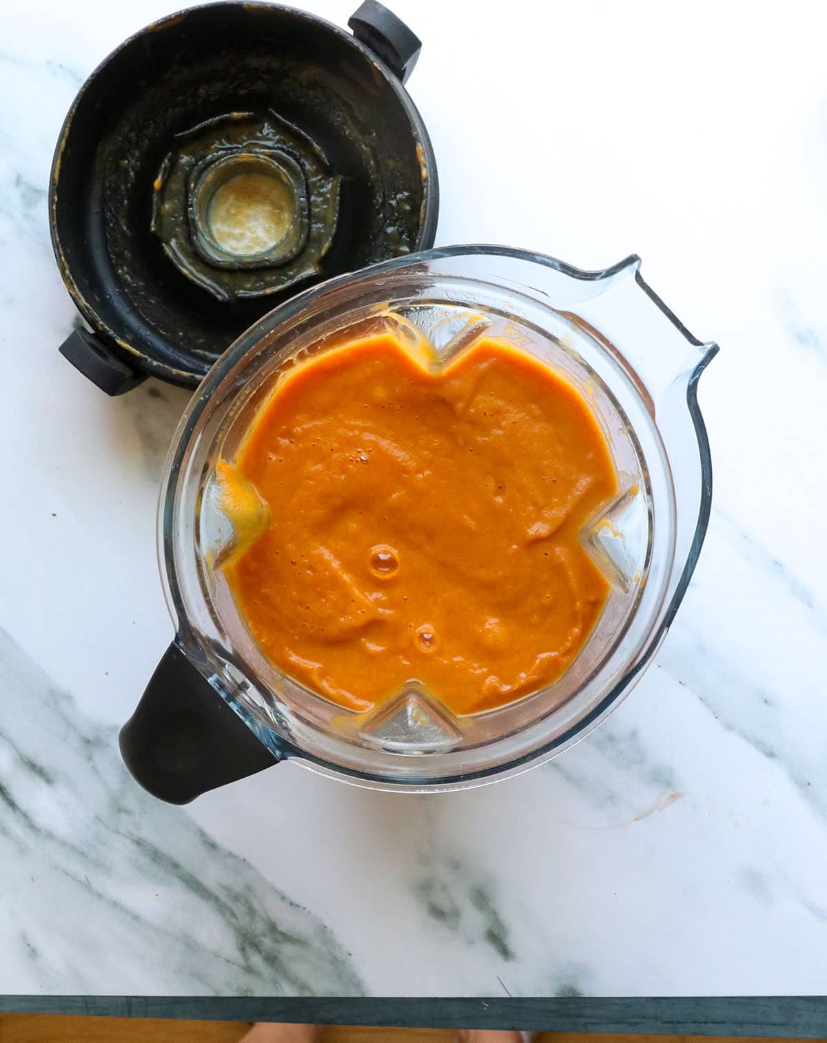 pureed pumpkin tomato soup in a blender with the lid off.