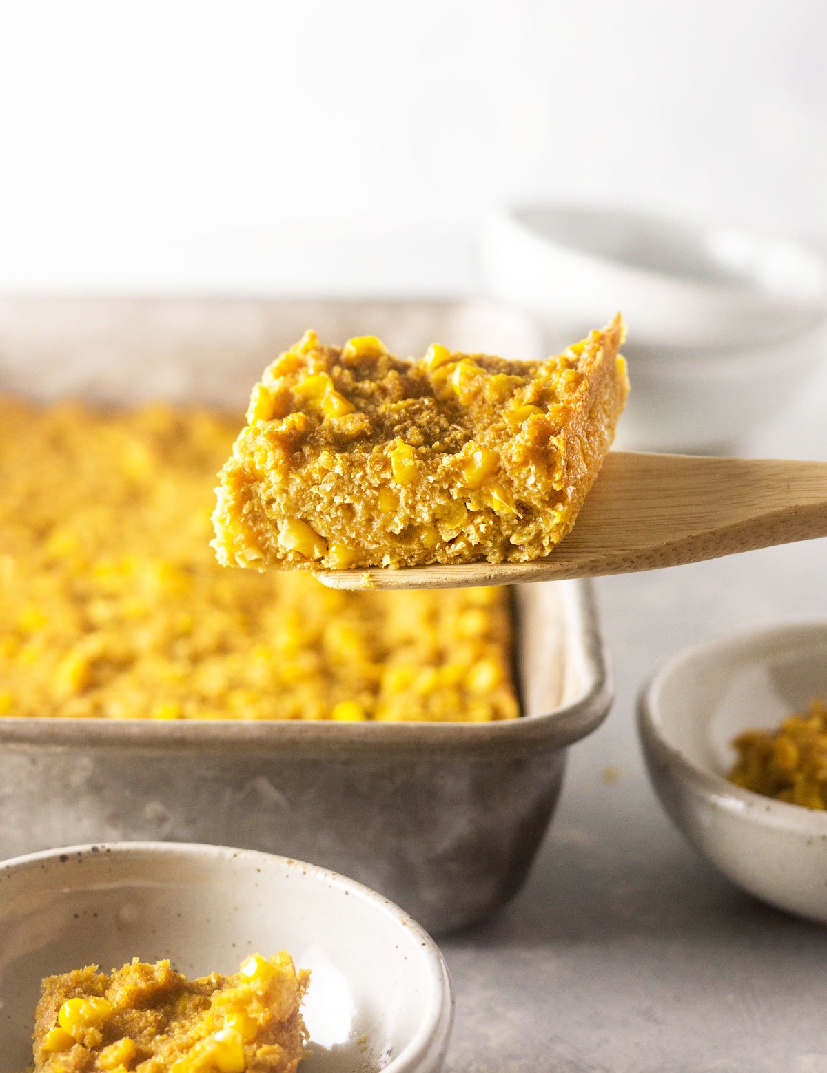 vegan corn casserole being scooped out of a pan