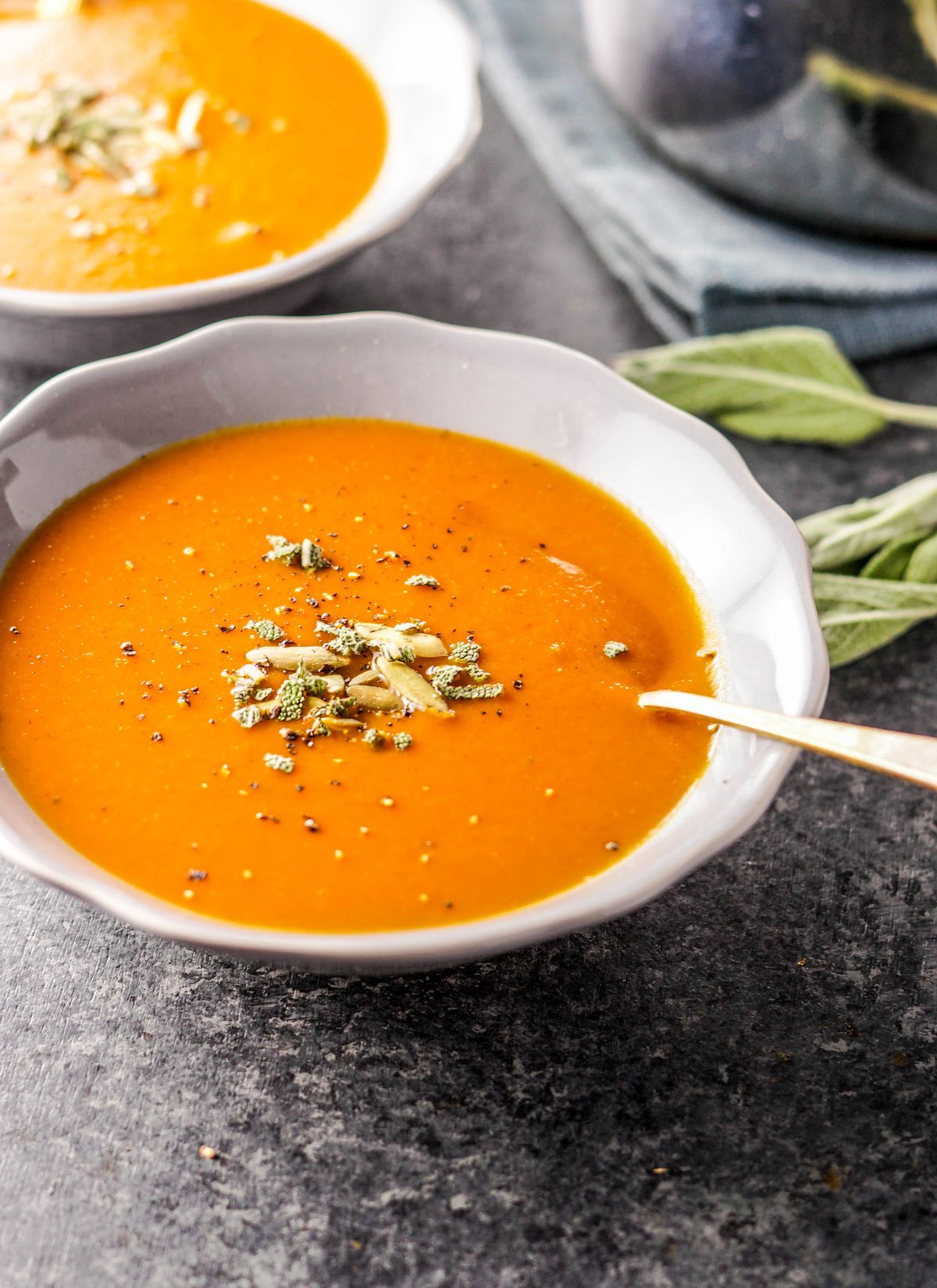 bowl of creamy pumpkin tomato soup with a spoon