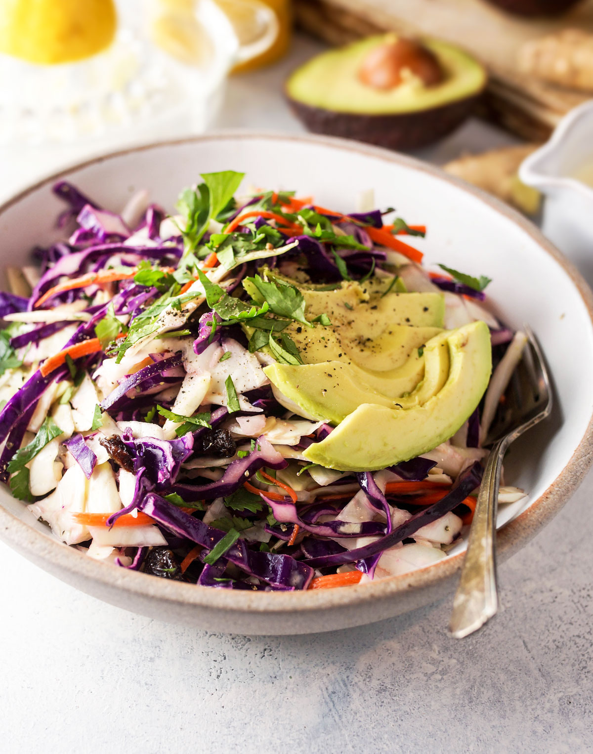 bowl of detox salad with lemon ginger dressing and slices of avocado on top