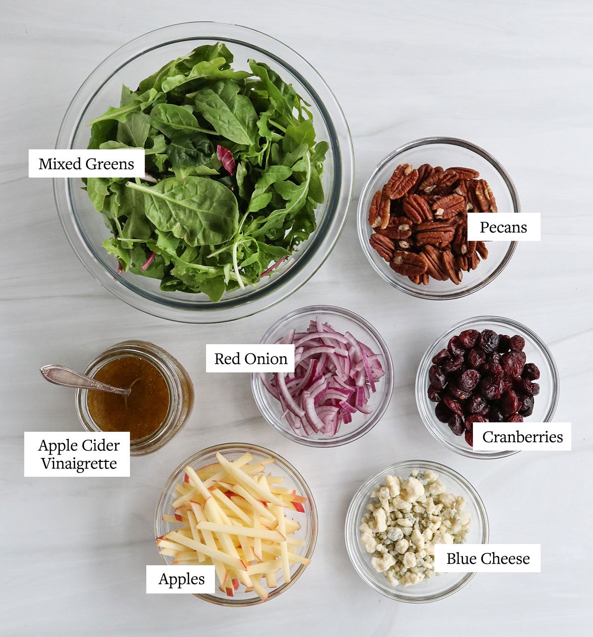 salad ingredients labeled in glass bowls.