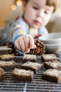 toddler putting sugar on black bean gingerbread bars
