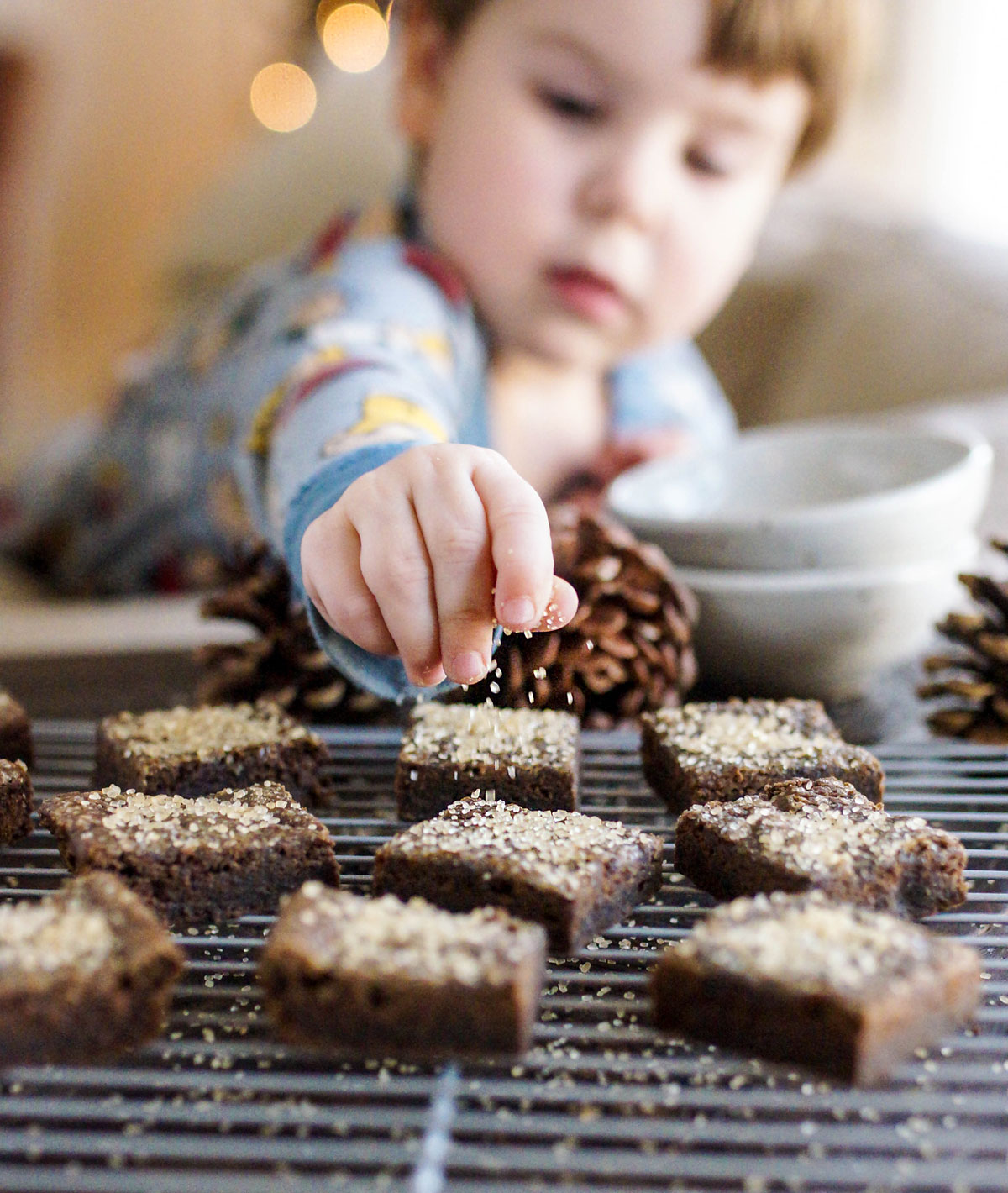 toddler sprinkling sugar over black bean gingerbread bars