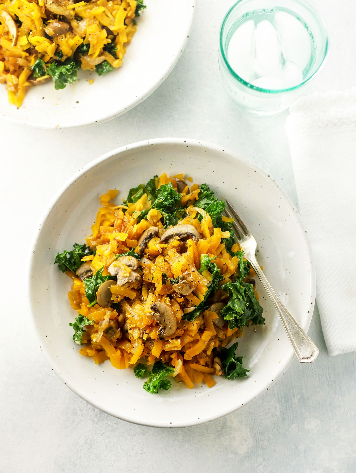 spiralized butternut pasta with mushrooms on a plate with a fork