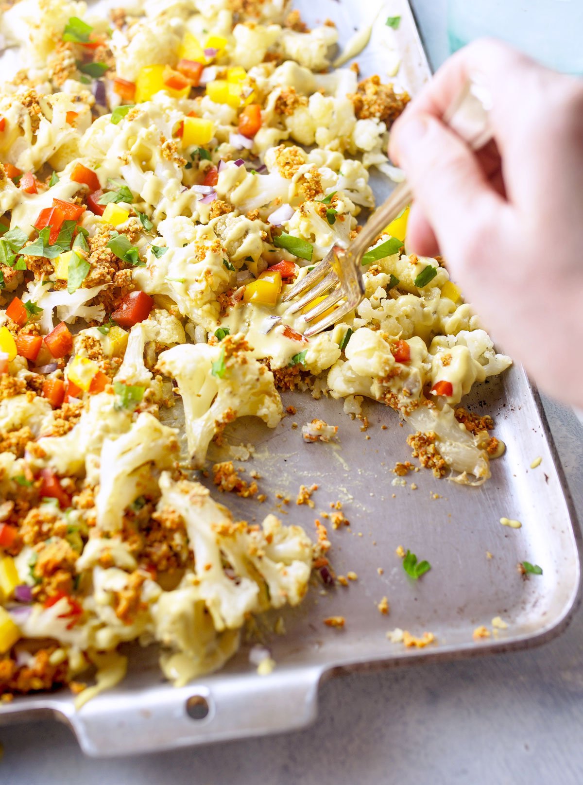 fork picking up cauliflower nachos from a pan