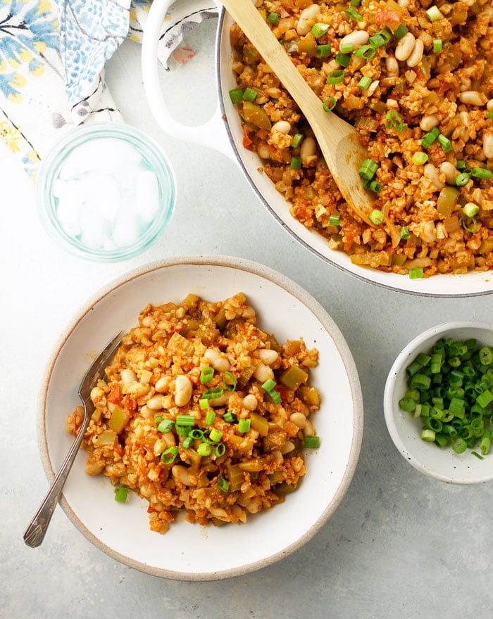 Creole-Style Cauliflower Rice Jambalaya in a bowl with green onions on top
