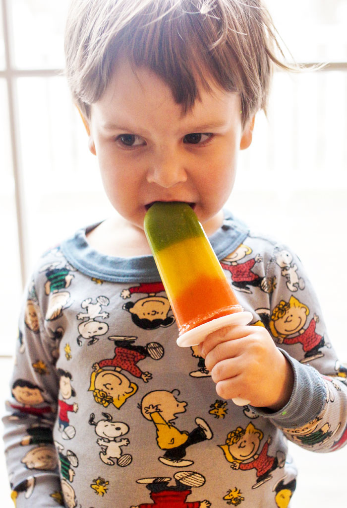 Little boy eating a layered popsicle