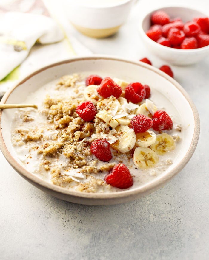 detox quinoa breakfast bowl with raspberries and bananas on top