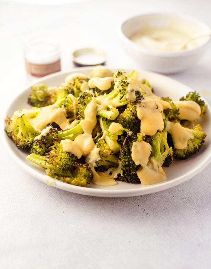 plate of broccoli with roasted cauliflower cheese sauce on top