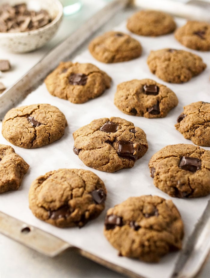 Buckwheat chocolate chip cookies cooling on a cookie sheet.