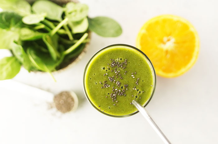 gorilla green smoothie in a glass with chia seeds and a straw on top