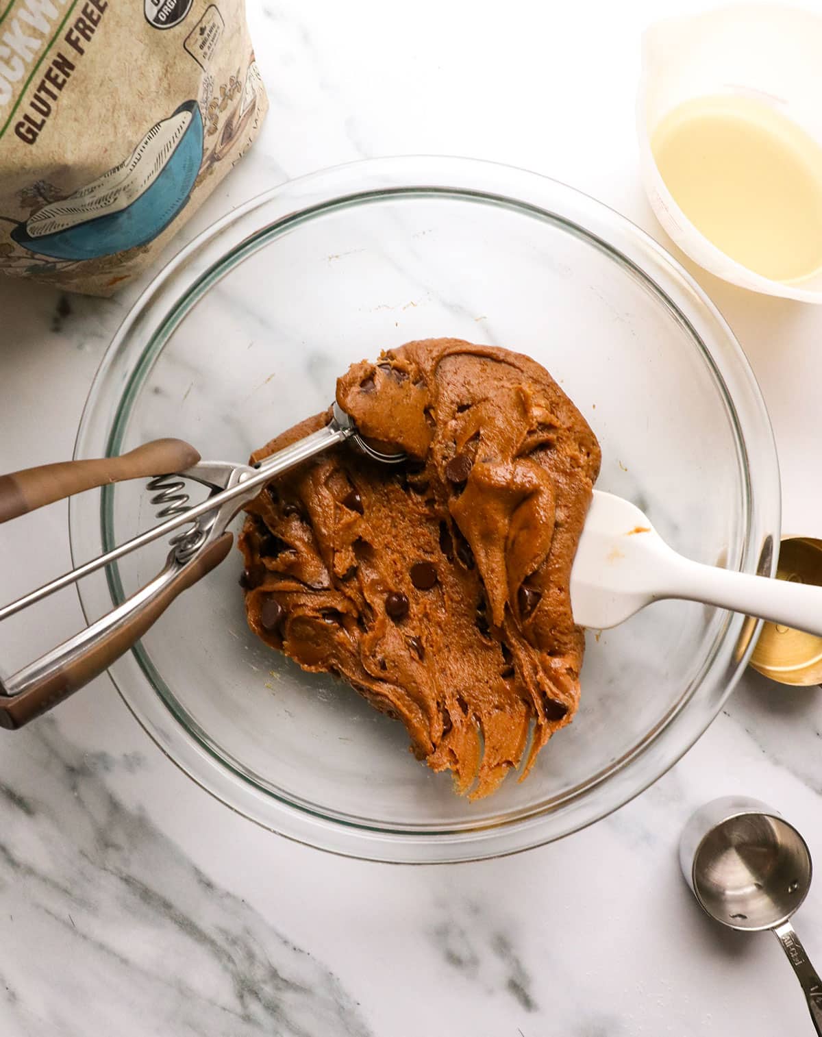 cookie scoop in a bowl of cookie dough.