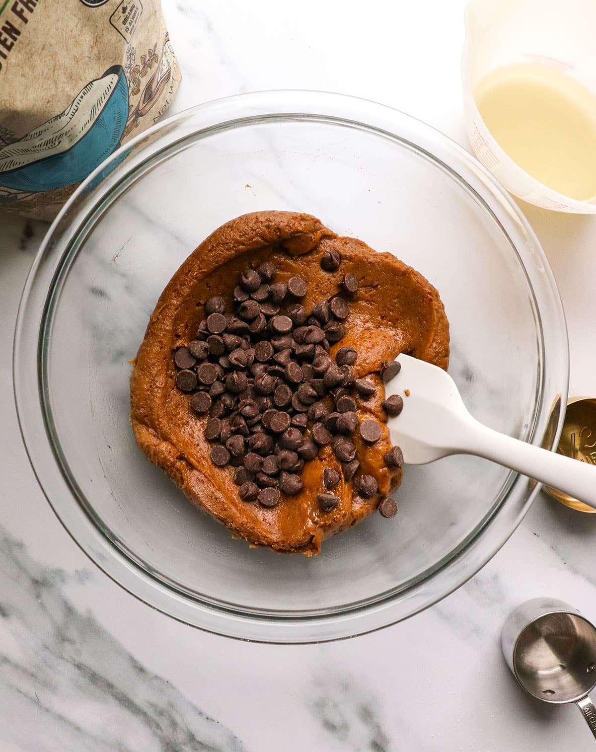 chocolate chips added to the buckwheat cookie dough in a bowl.