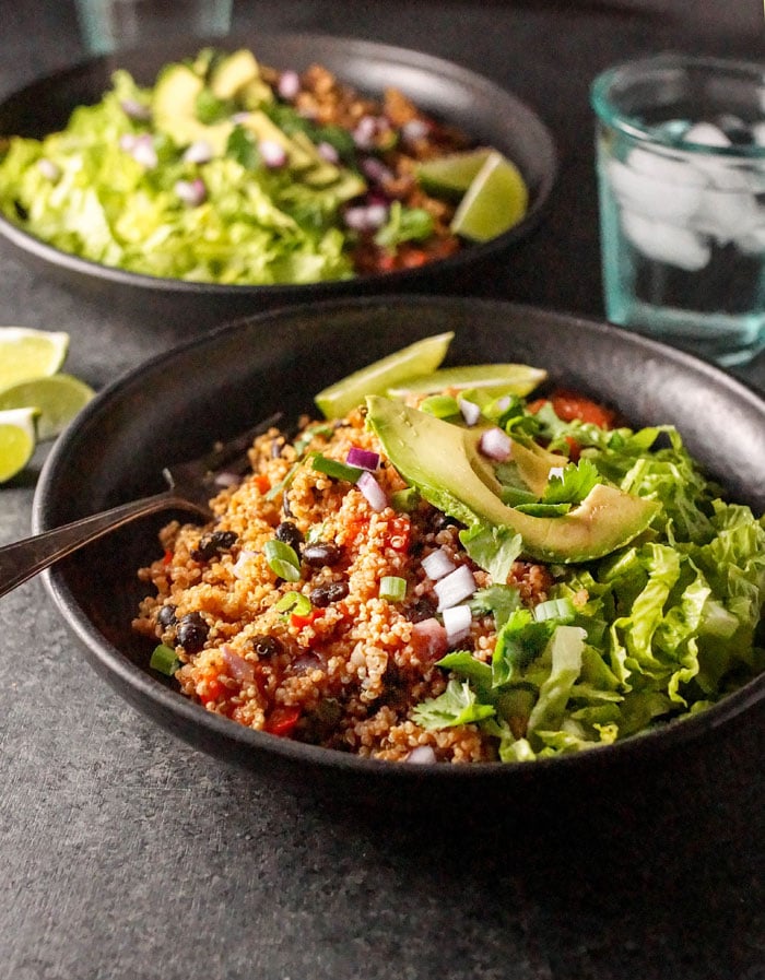 Instant Pot Vegan Quinoa Burrito Bowls on a plate with avocado slices on top