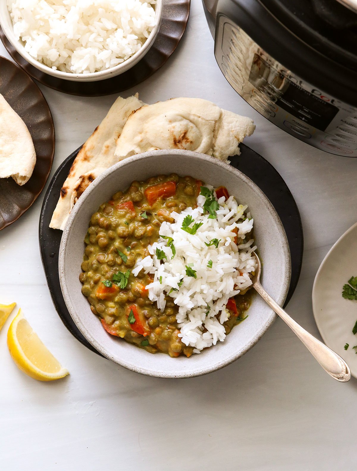 Instant Pot Lentil Curry served in a white bowl with rice and naan bread.