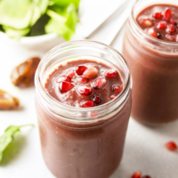 acai smoothies topped with pomegranate seeds in glass jar