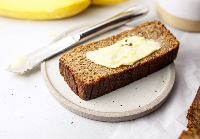 slice of coconut flour banana bread with butter spread on top