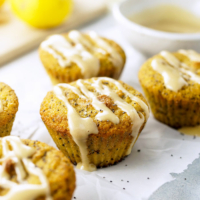 coconut flour lemon poppy seed muffins with icing on counter