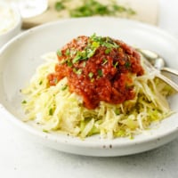 bowl of cabbage topped with spaghetti sauce