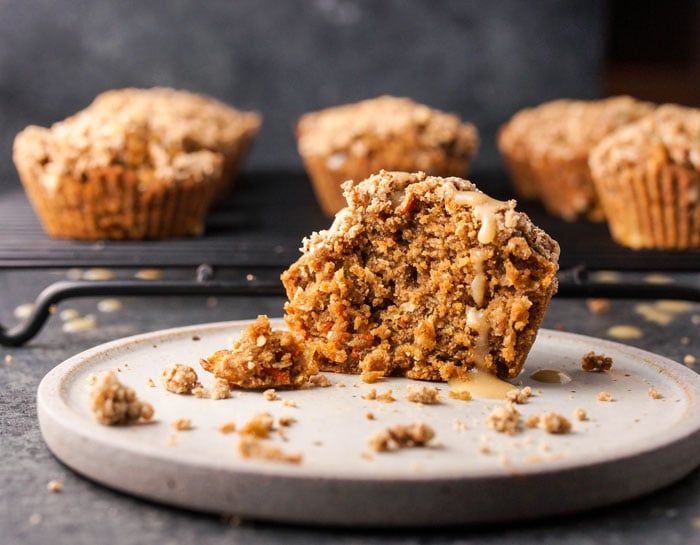 half of a gluten-free carrot cake muffin on a plate