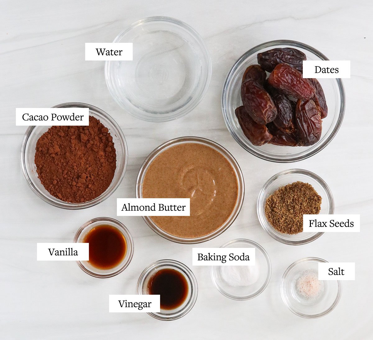 date brownie ingredients labeled in glass bowls.