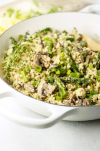 vegan cauliflower rice "risotto" with asparagus and mushrooms in a pan