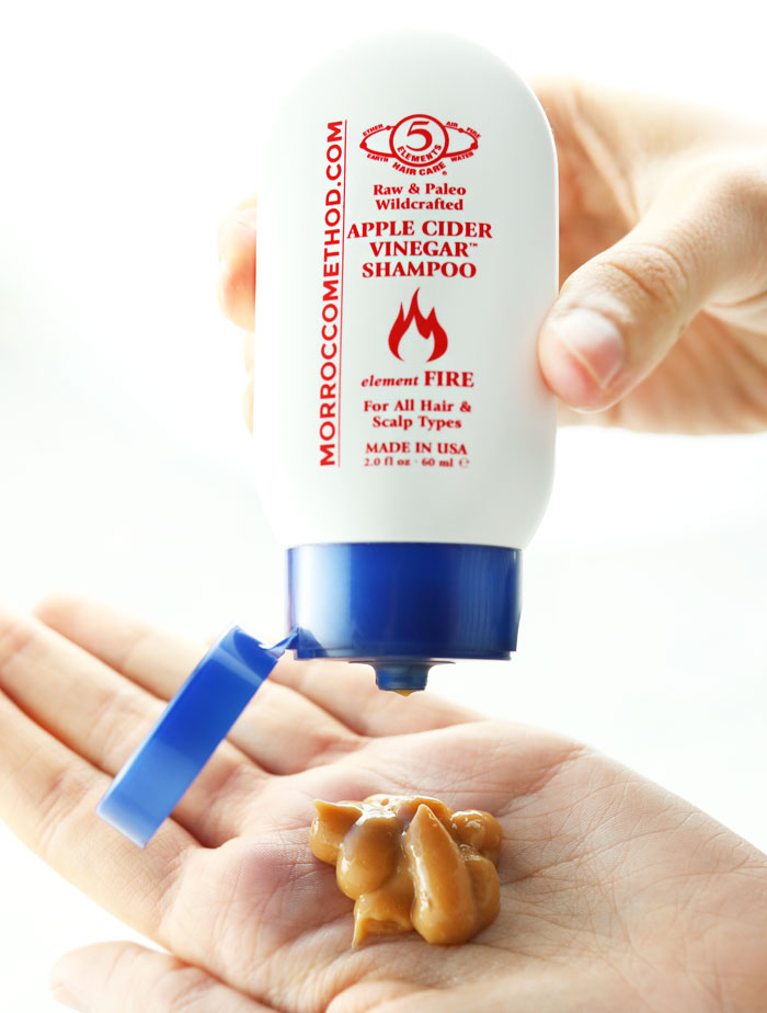 hand squeezing morrocco method apple cider vinegar shampoo onto hand