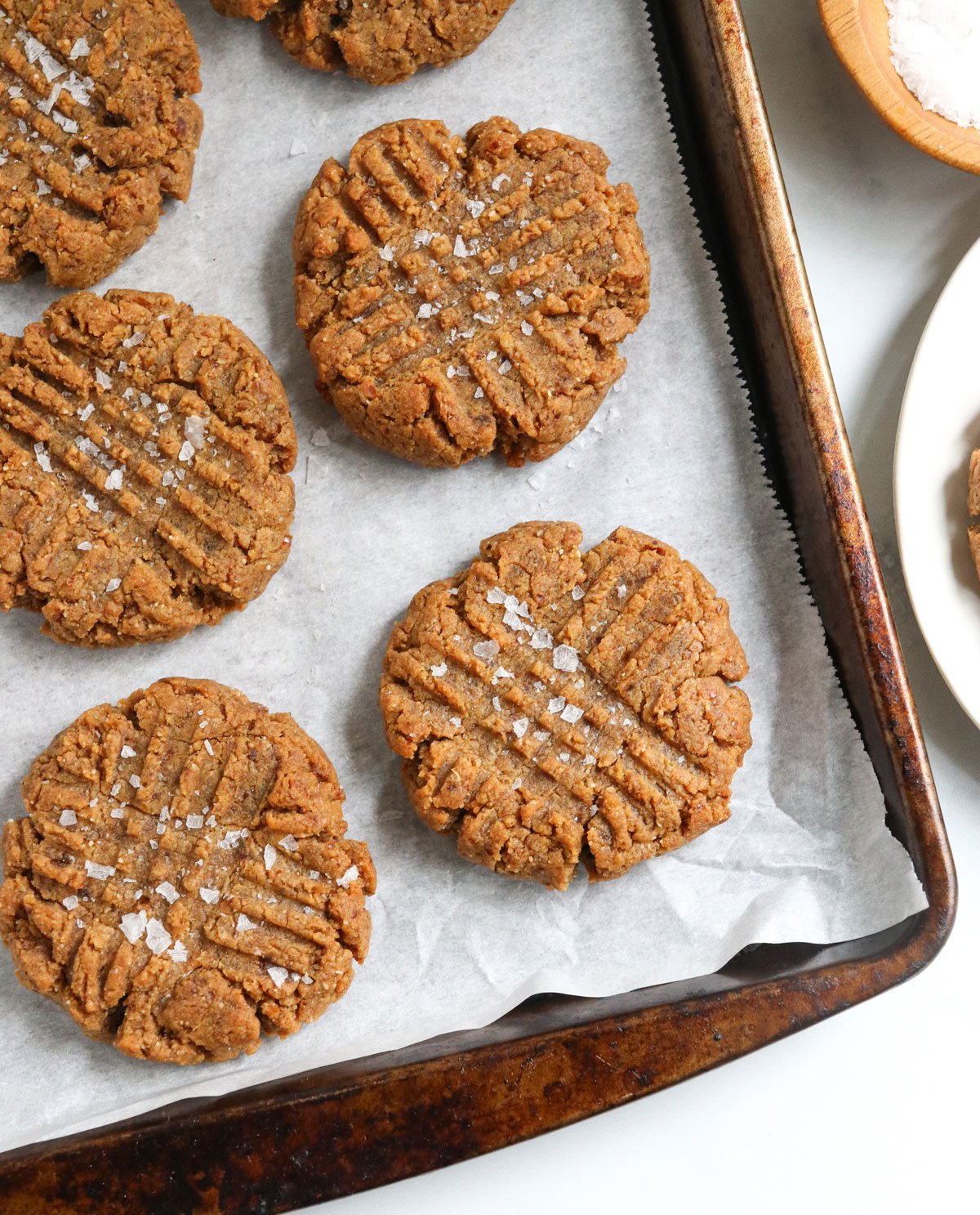 peanut butter date cookies on pan with salt