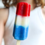 A child holds red white and blue popsicles.