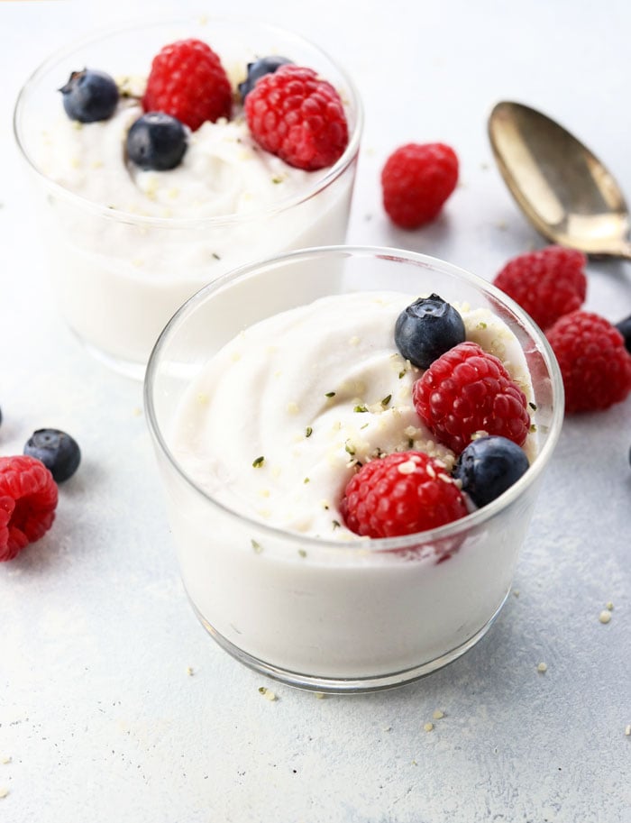 two cups of dairy free coconut milk yogurt topped with berries