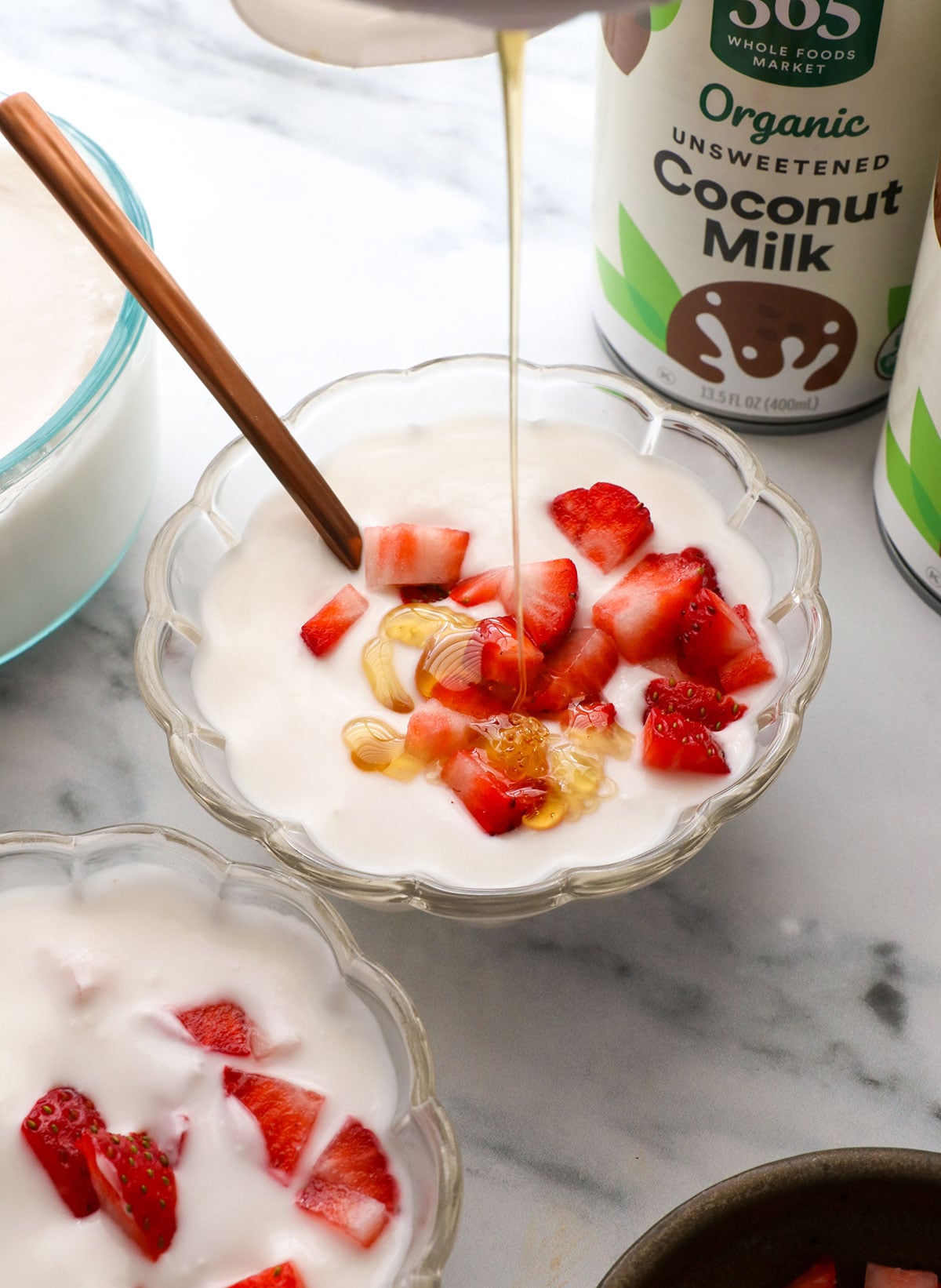 honey added to homemade coconut yogurt with strawberries.