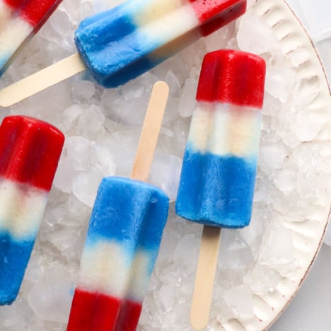 red white and blue popsicles on a plate with ice.