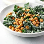 Vegan Kale Caesar Salad is made with a dairy-free tahini dressing and topped with Garlic Roasted Croutons in bowl