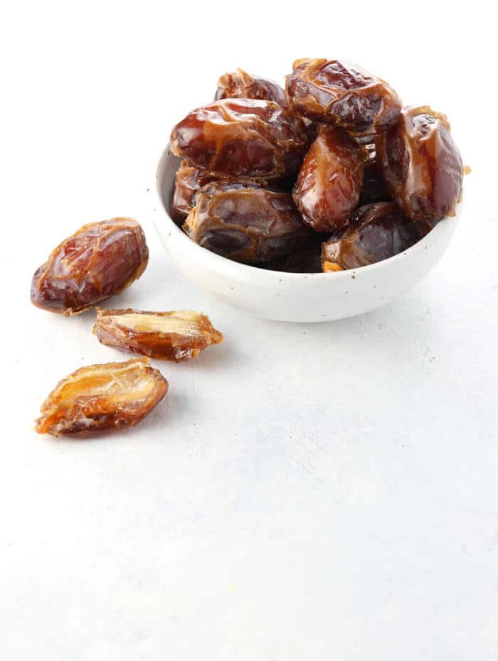 Medjool dates in a bowl on white background