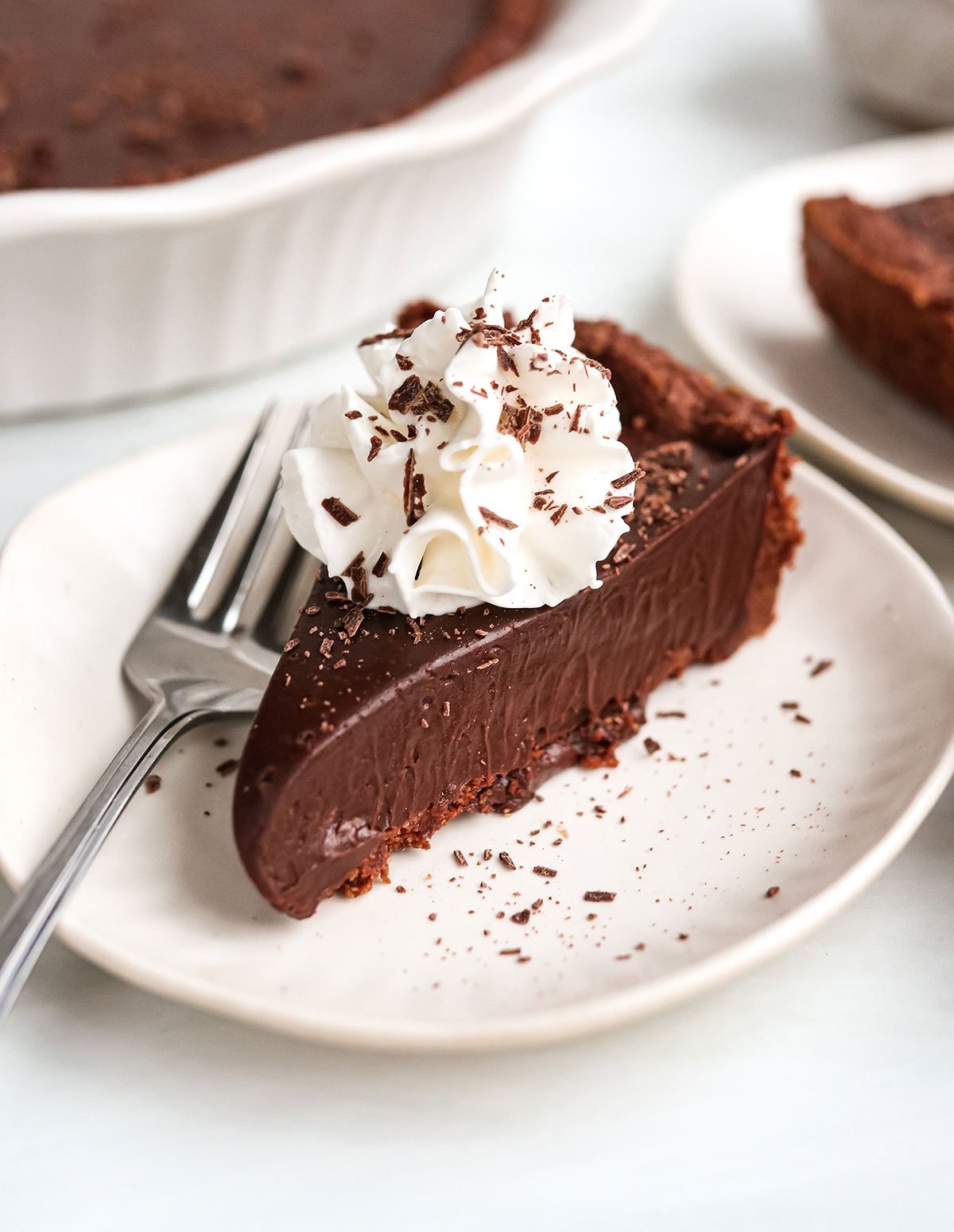 slice of vegan chocolate pie with whipped cream on top.