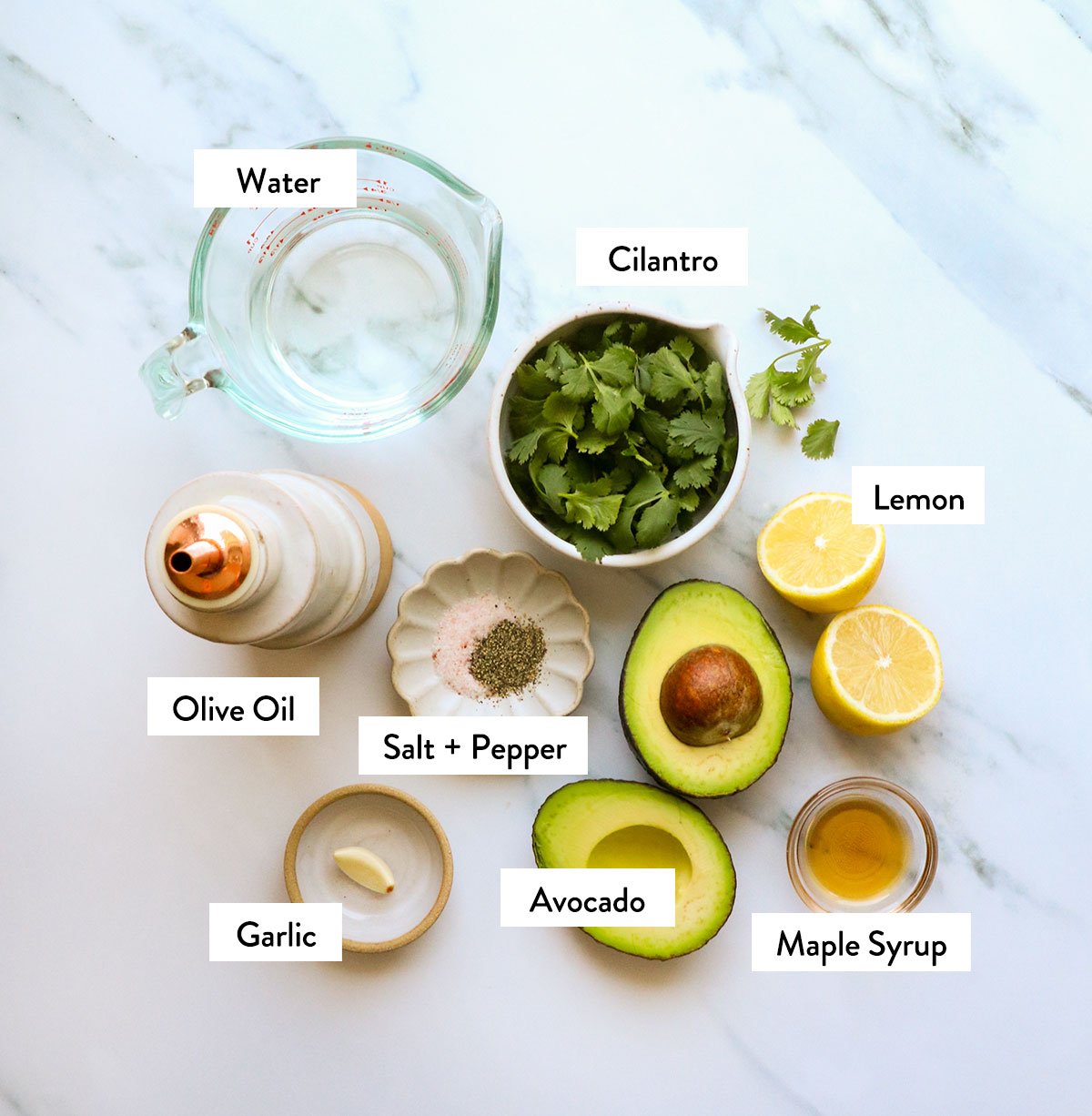 avocado, cilantro, lemon, and spices labeled on a white surface.  - 3