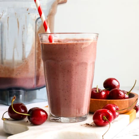 Cherry chocolate smoothie served with a straw.