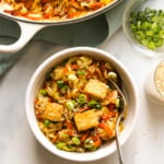 vegan egg roll in a bowl topped with tofu next to a skillet.