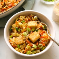 Vegan Egg Roll in a Bowl topped with tofu and served with a fork in a white bowl.