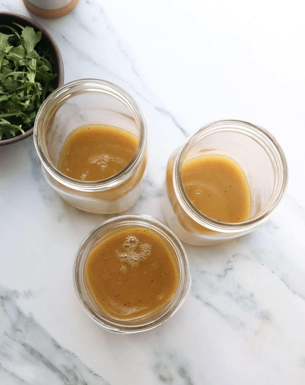 apple cider vinaigrette divided between 3 quart-sized mason jars. 