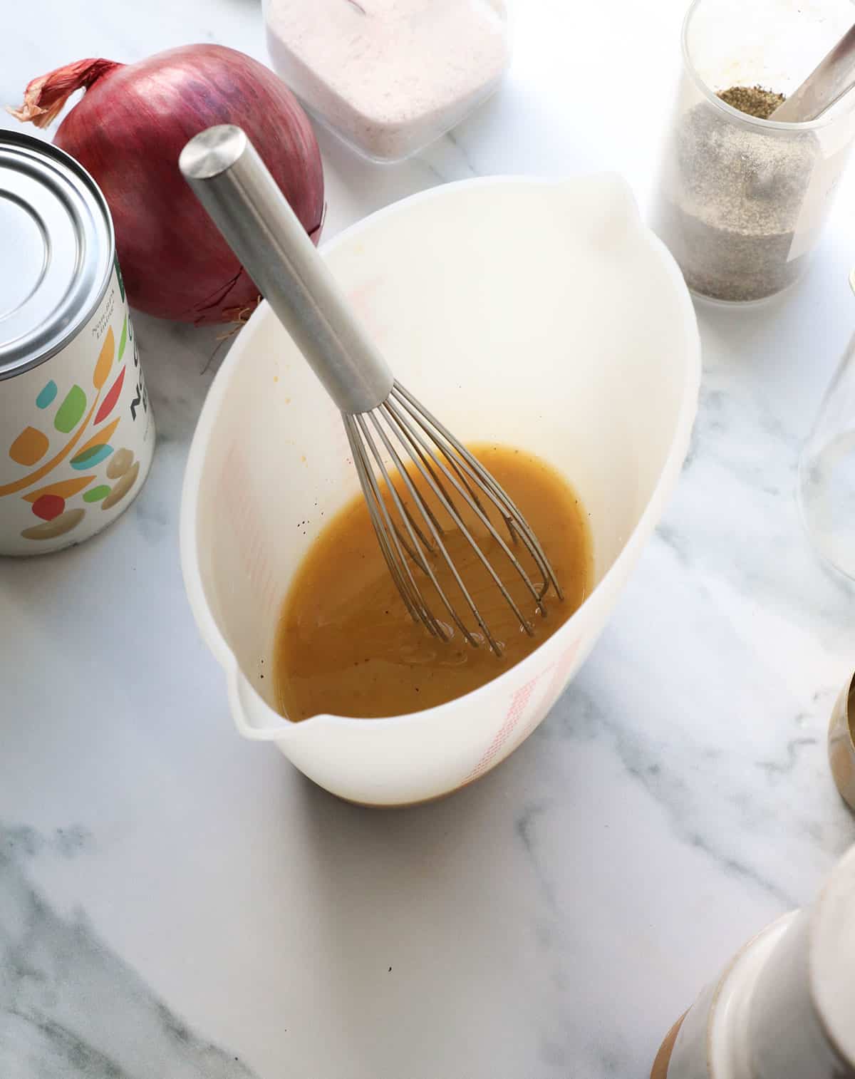 apple cider and maple dressing whisked in a silicone measuring cup. 