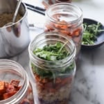 mason jar topped with sweet potatoes and arugula.