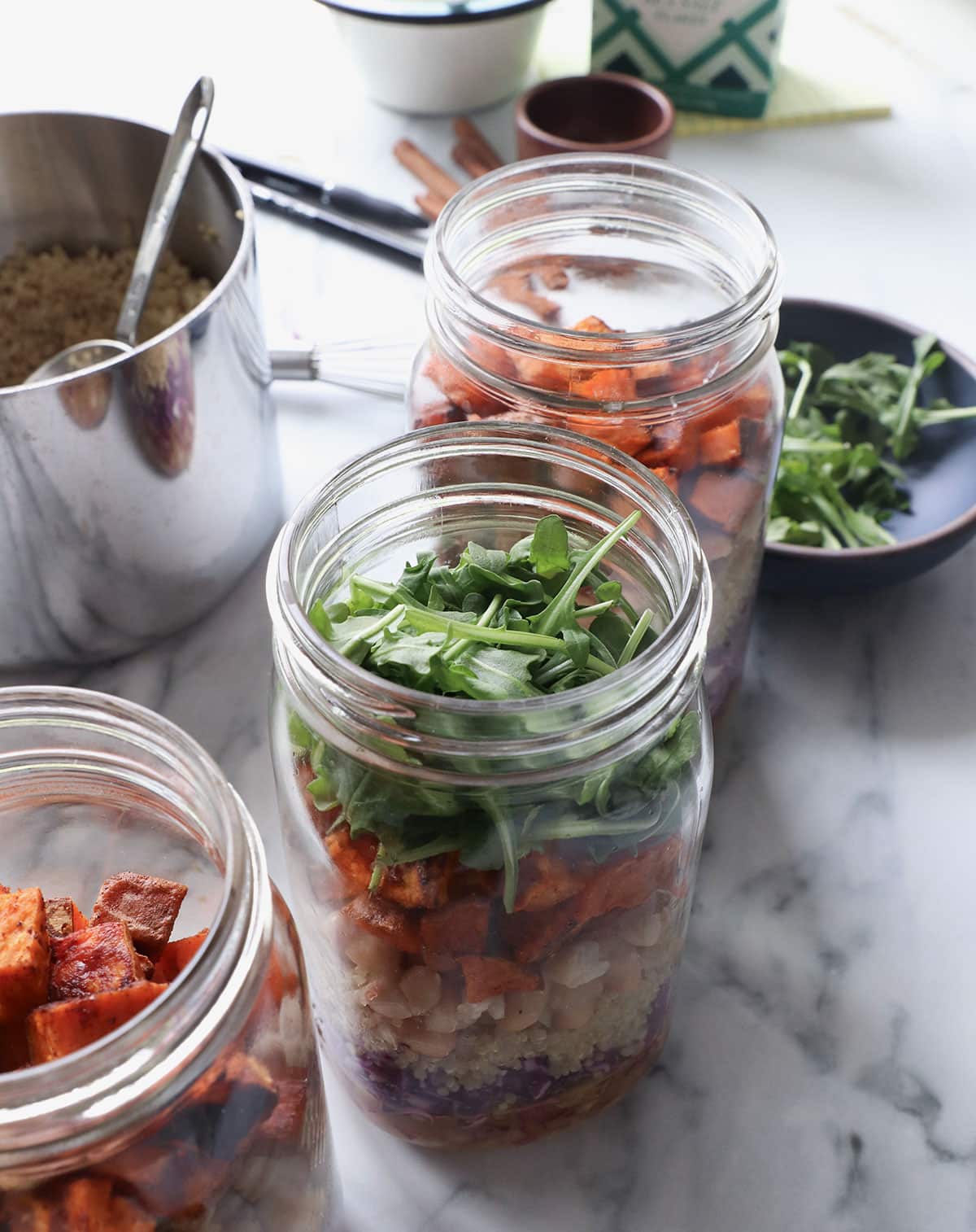 mason jar topped with sweet potatoes and arugula. 