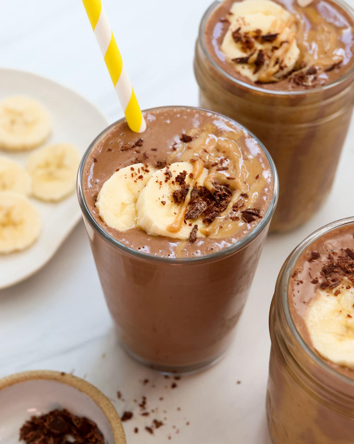 chocolate peanut butter smoothie in glasses with straw