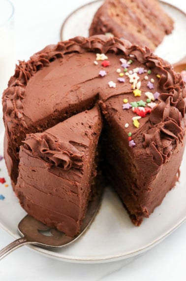 healthy birthday cake sliced with chocolate frosting on top.