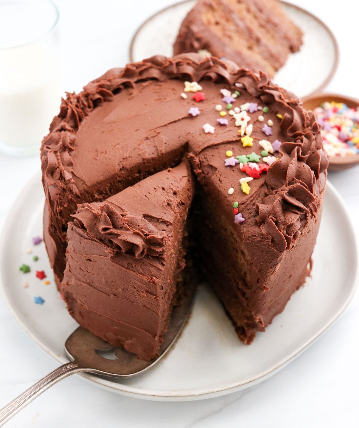 healthy birthday cake sliced with chocolate frosting on top.