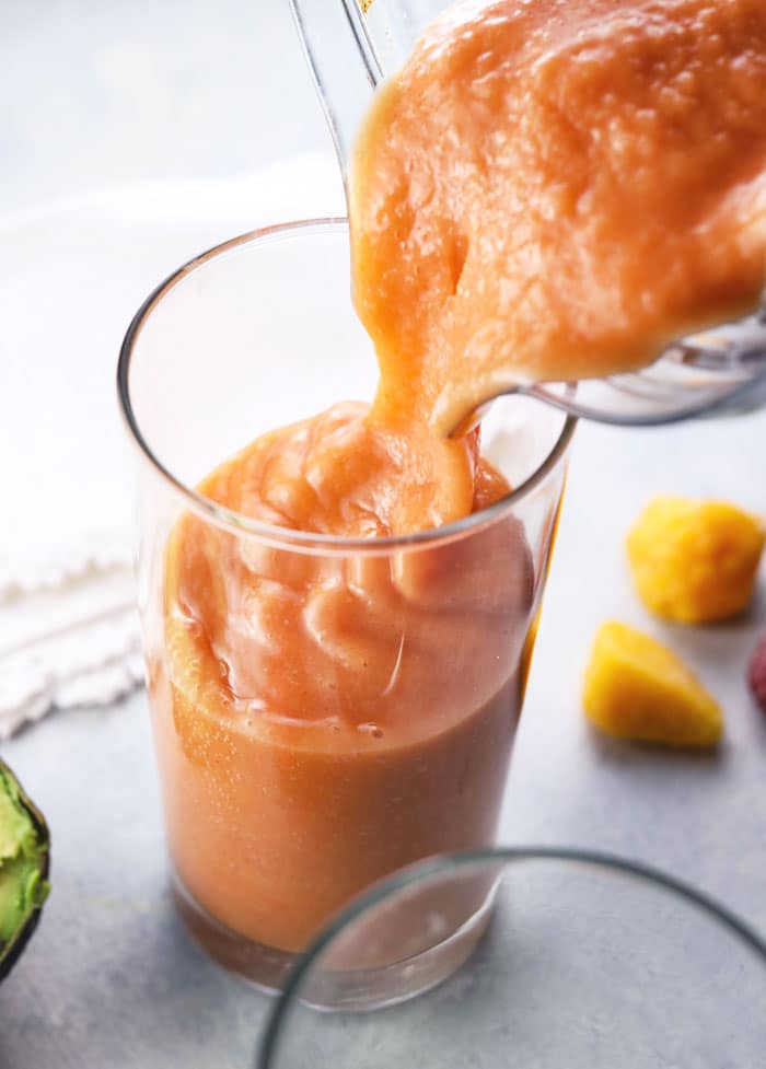 vitamix pouring strawberry mango smoothie into a glass