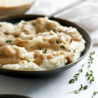vegan gravy on mashed potatoes with fresh herbs
