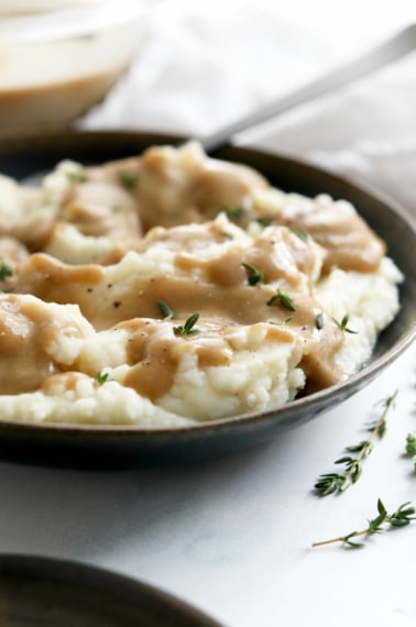 vegan gravy on mashed potatoes with fresh herbs