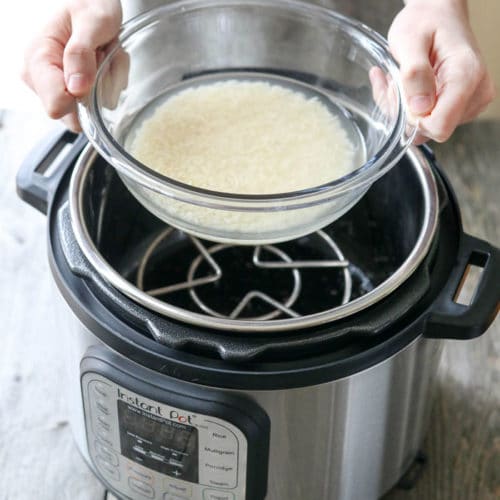 hands holding bowl of rice over Instant Pot
